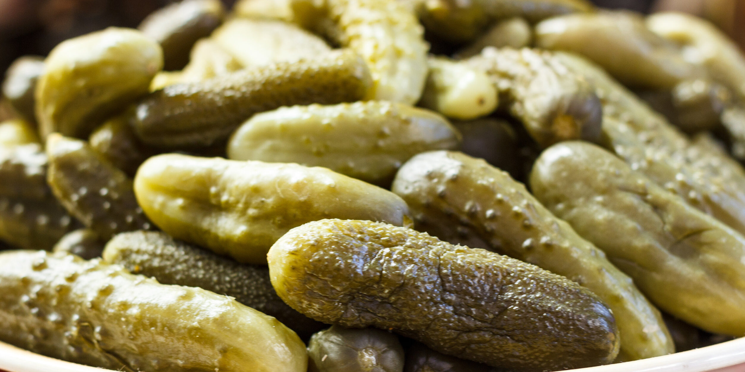 Close-up of pickled green cucumbers with dill and spices