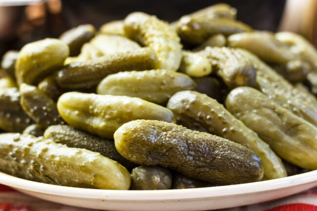 Close-up of pickled green cucumbers with dill and spices