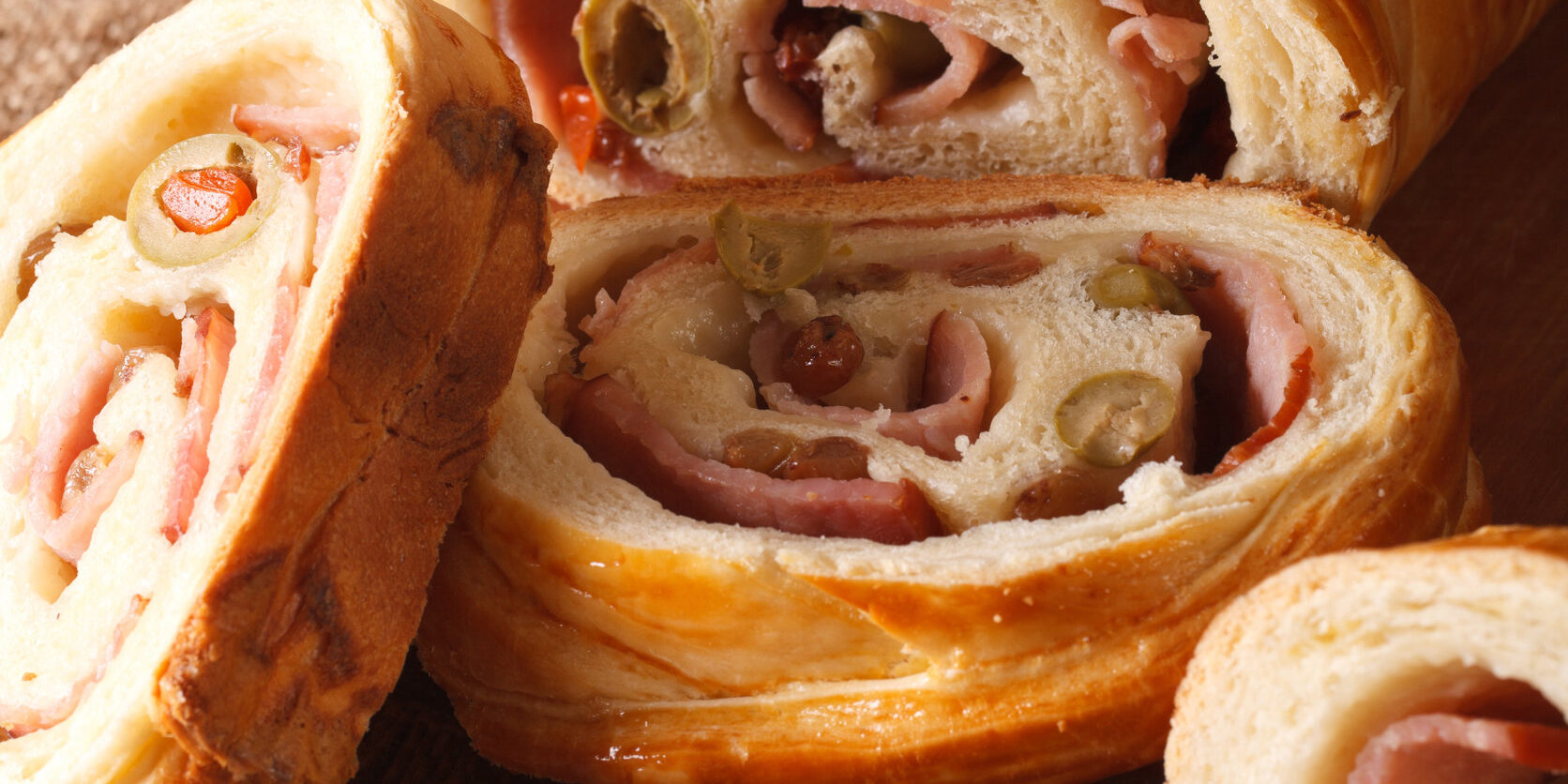 sliced bread stuffed with ham and olives close-up vertical