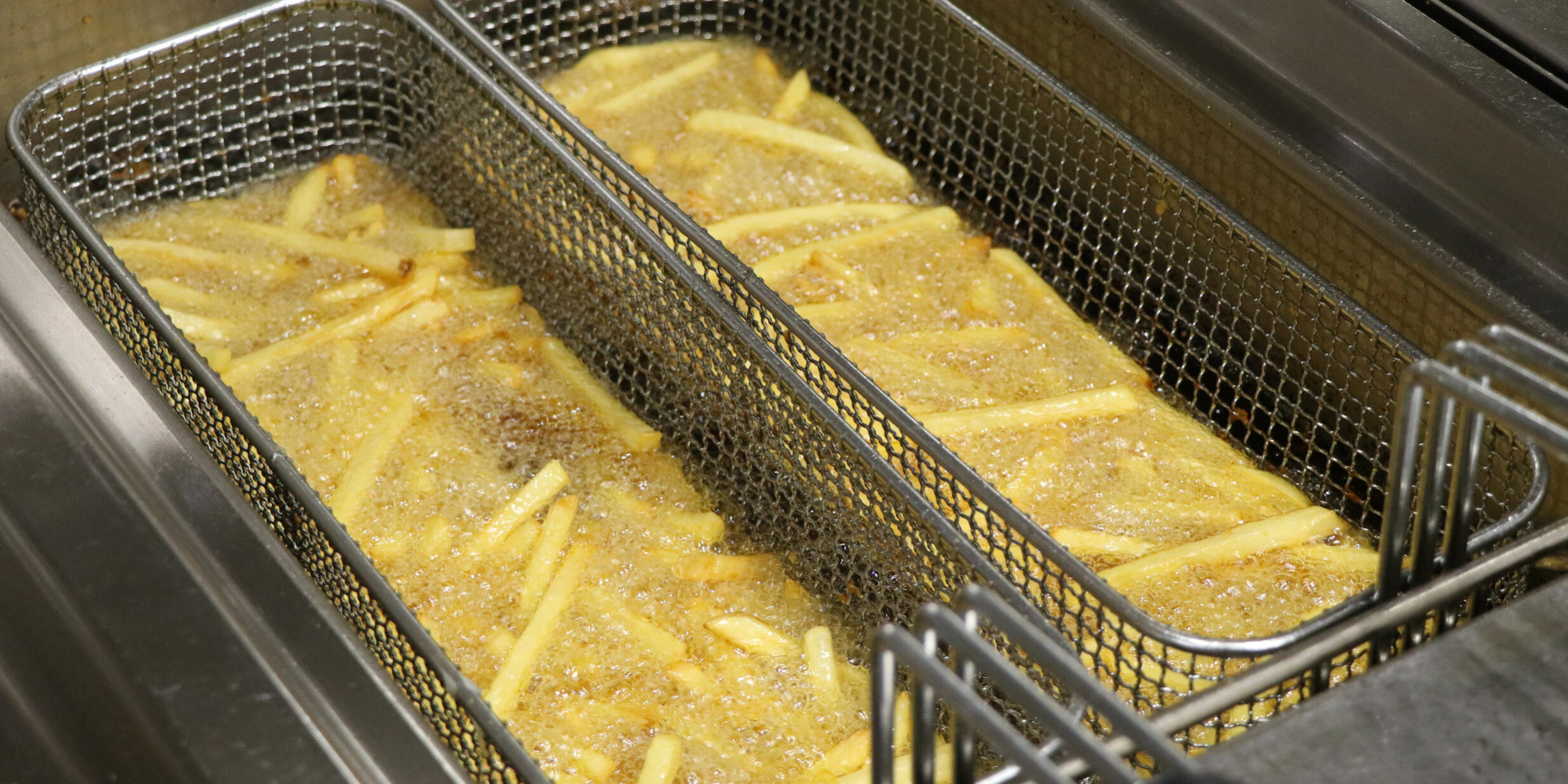 potato chicps frying in a deep fryer
