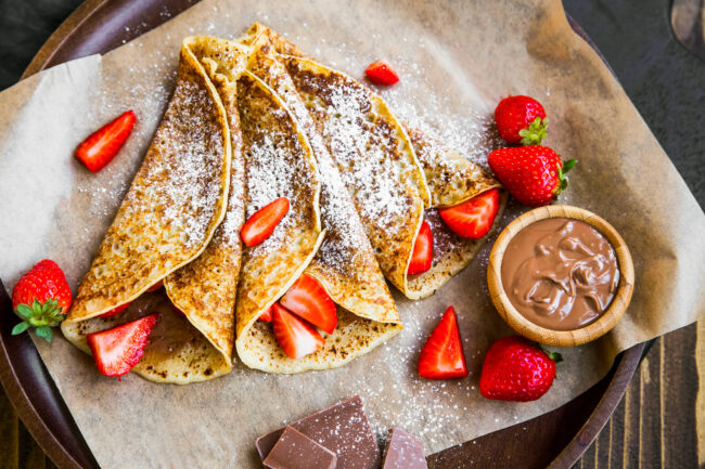 French crepes with chocolate spread and strawberries