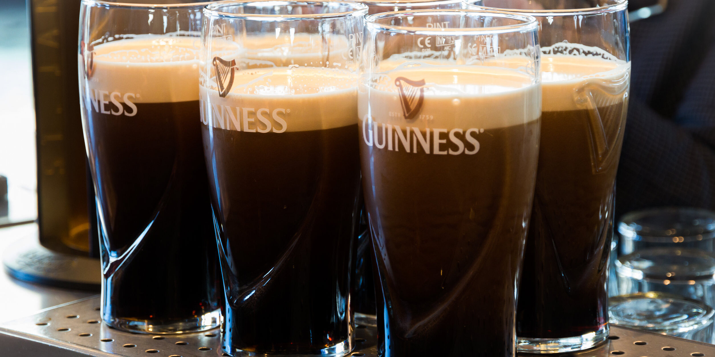 Pints of Guinness are being served in a pub in Dublin, Ireland