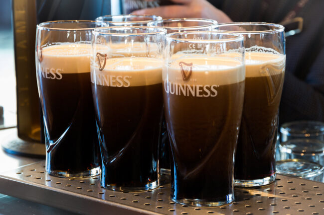 Pints of Guinness are being served in a pub in Dublin, Ireland